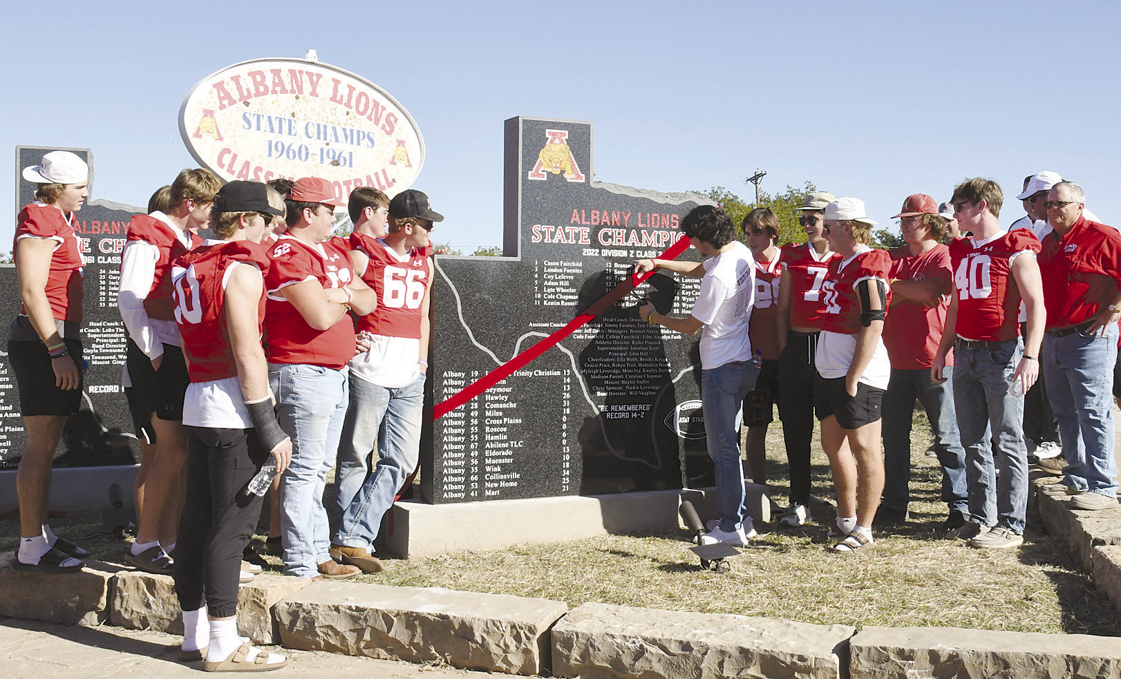 John Woodward (above, c) cuts the ceremonial ribbon dedicating the 1960 state champion monument, while London Fuentes (at left), a member of last year’s team, does the honors for the 2022 monument. Donnie Lucas / Albany News