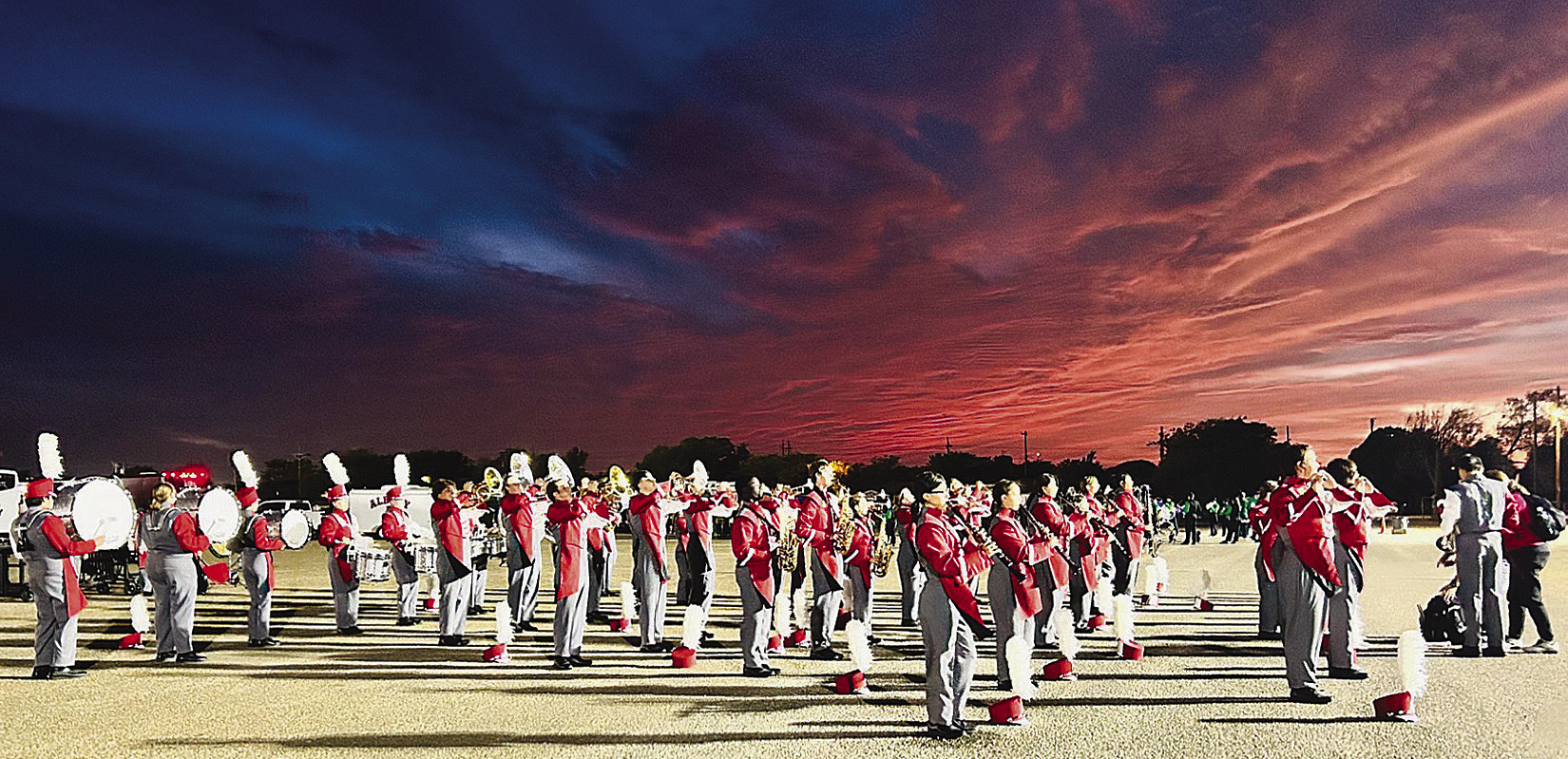 With a Panhandle sunset behind them, members of the Ragin’ Red Band warm up for their second performance in the area competition in Amarillo last Saturday. The musicians made school history by making the finals, breaking into an elite group. Courtesy Photo By Kell i Kreitler