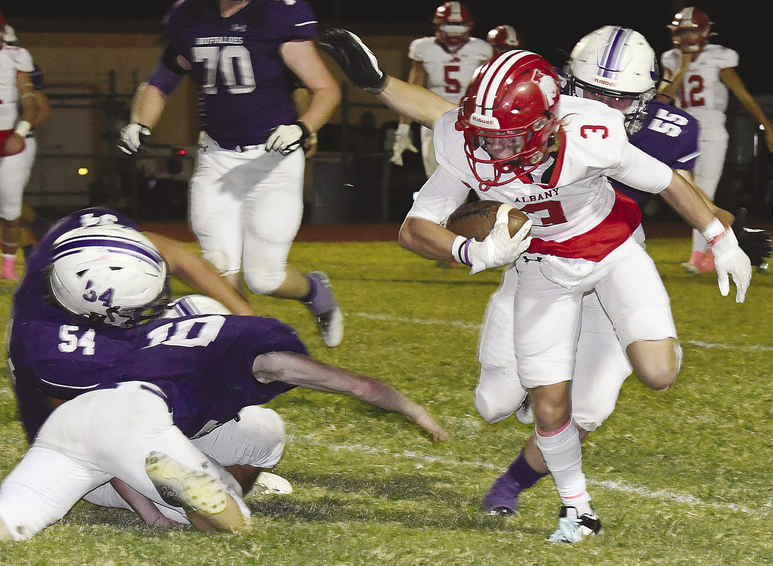 Adam Hill (above) twists through the Cross Plains secondary on his way to a running touchdown as the Lions win a lop-sided 49-0 district game last Friday on the road. Branson Beal (at right) bounces off two would-be tacklers and outruns another for a fourth quarter first down. Donnie Lucas / Albany News