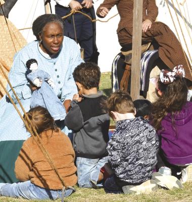 One of the participants in the 2023 Living History event (at left) tells a group of preschool students about several different kinds of dolls and other toys, including the fact that “soft dolls” were good for going to church because they didn’t make noise when they were dropped. Another good crowd is expected at this year’s event, set for Oct. 11-12. Albany News File Photo