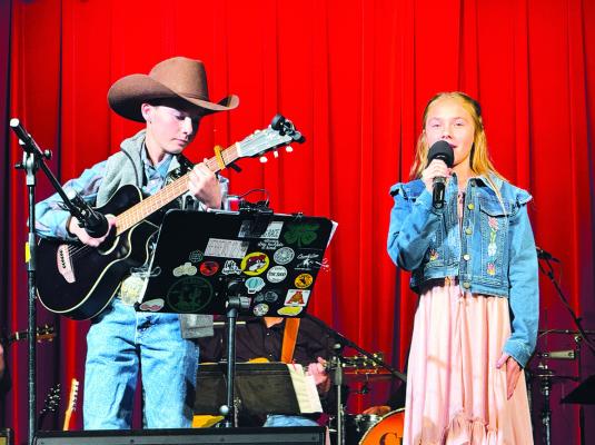 Ayers Bezner (l) accompanies his sister Dally Bezner (r) for one of the numbers presented at last Saturday’s Aztec Musical, this year featuring “Our Songs.” The Bezners, along with Josephine Sanders, were the youngest in the line-up of musicians and vocalists for the annual event, which was organized by Sandy Abel. Courtesy Photo