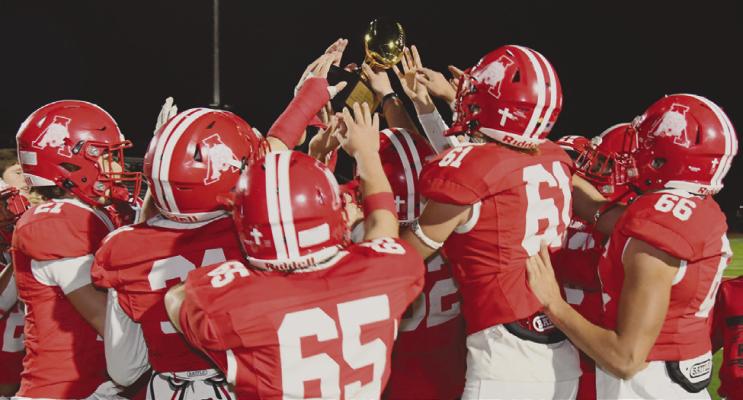 Lion players lift the area championship trophy in Graham after their 48-14 win over Archer City. Donn ie Lucas / Albany News