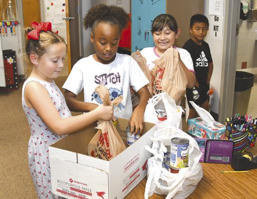 Students in Kenzie Fairchild’s second grade at Nancy Smith Elementary School contribute to the box in their classroom that will be counted as part of Albany’s overall donation in the annual food drive contest. Winners will be announced Friday. Donnie Lucas / Albany News