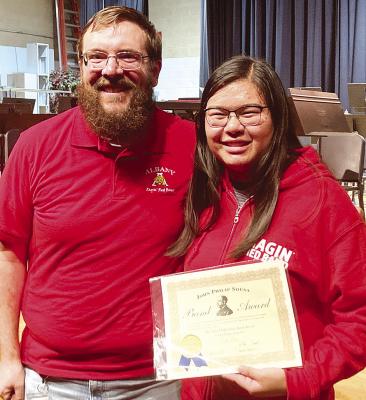 Band director William Vaughan (l) awards senior Jade Bean (r) with the John Philip Sousa Award during last Thursday’s high school band concert. Concerts for the other bands were re-scheduled to today because of conflicts. Courtesy Photo