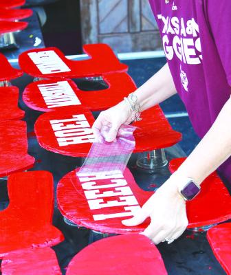 Tisha Wilkins positions names on the wooden football helmets that quickly made their way onto the “playoff board” at the Bank Park this week. The Lions will play Eldorado tonight, with a send-off planned at 3:00 p.m. this afternoon. Donn ie Lucas / Albany News
