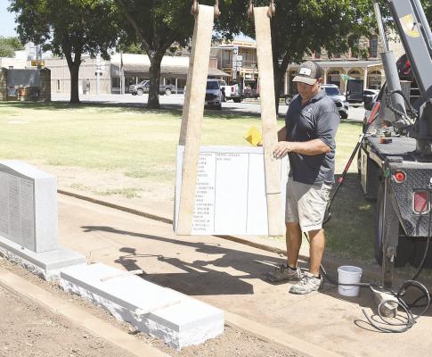 One of two new stones honoring Shackelford County veterans is guided into place on the north side of the Courthouse Square earlier this month. The two new monuments, one of which contains only World War I names, were paid entirely with donations from local supporters. Donnie Lucas / Albany News