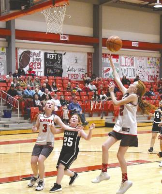 Seventh grader Tinley Hefner goes under the basket for a lay-up during the junior high girls match-up against Anson. The Albany teams won three of four of their Monday games. Donnie Lucas / Albany News