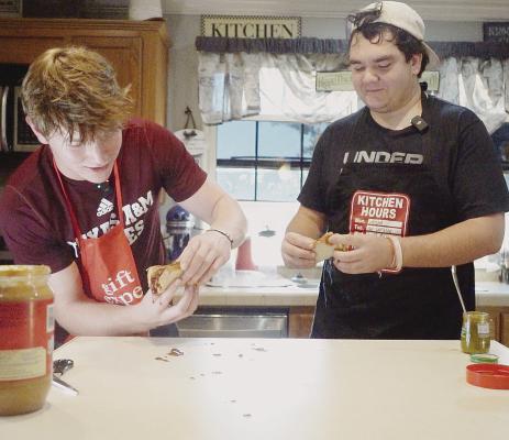 AHS student-athletes Tyler Chapman (l) and Landon Balliew (r) put together a sandwich that has been the “worst so far” in an Instagram video challenge. The pair is raising money for a local elementary student treated for cancer. Photo From Video By Julia Vega