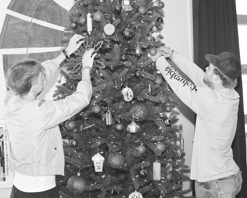 Brayden Watson (l) and Lanxton Viertel (r) place some ornaments on the 12-foot Christmas tree at The Feed Store. The youth facility, along with churches in the community, is preparing for activities during the upcoming holiday season. Donn ie Lucas / Albany News