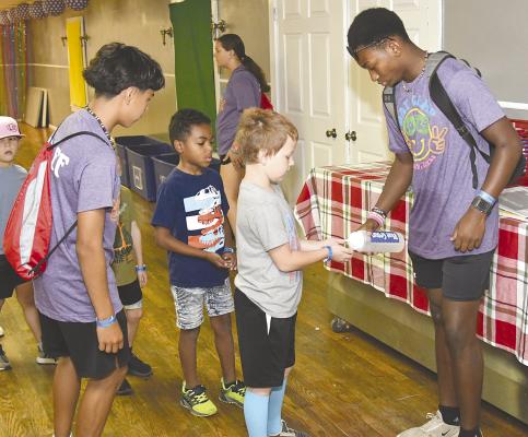 Student worker Jakobi Roberson (r) dispenses hand sanitizer to participants at this year’s ResourceCare Day Camp. The event runs through next week, with well over one hundred children enrolled. Donnie Lucas / Albany News