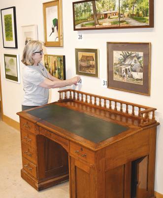 Amy Kelly puts a number in place for one of the pieces to be offered in the Old Jail’s biennial art auction coming up this Saturday, Nov. 11. The sale of 63 separate lots, including some antique furniture, will benefit the OJAC Acquisitions Fund. Bidding is already underway. Donnie Lucas / Alba ny News