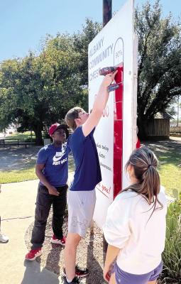 John Birkla (c) removes red squares depicting percentages achieved last year during the Albany Chest campaign, as local ag students get the “thermometer” installed and give it a clean start for the 2024 drive. A $48,000 goal has been set. Melinda Lucas / Albany News