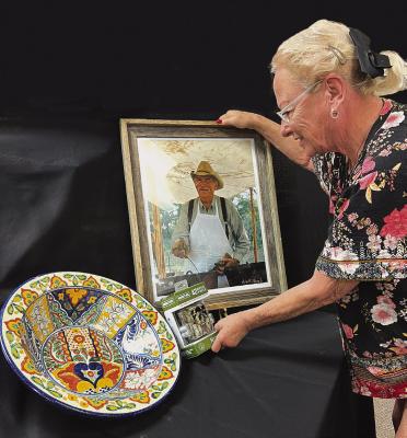 Friends of Fort Griffin coordinator Susan Waller arranges a few of the items to be available for auction at the 20th annual Gala Saturday night. Among them is a framed Watt Casey photo of the late Bill Cauble, in whose memory the Gala is being held. Melinda Lucas / Albany News