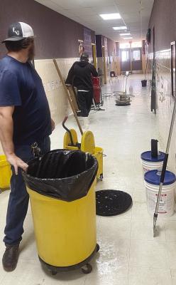 With a goal of making the hallway tile look brand new, Moran ISD employees work through the holiday break to strip and refinish floors. They have also been busy repairing a bus in case it is needed to add another route because of the closure of the Hwy. 180 bridge that is part of the route to bring transfer students from Breckenridge and Albany. Photo Provided By Moran School