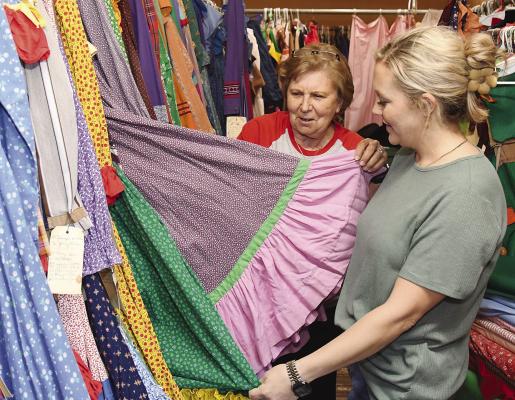Surrounded by colorful dresses in the Fandangle box car, costume coordinator Myra Hise (l) and cast member Kirsten Hilliard (r) decide on one for the upcoming Membership Sampler. The cast and crew continue to rehearse for the April 20 event at Collins Creek Ranch. Donnie Lucas / Albany News