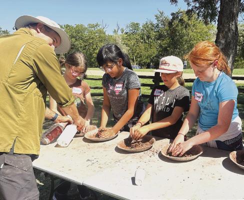 NSES fourth graders “get their hands dirty” at one station during the Kids on the Land program at Lamshead Ranch last week. Students learn about the habitat around them and hopefully become better stewards of their own environment. Courtesy Photo
