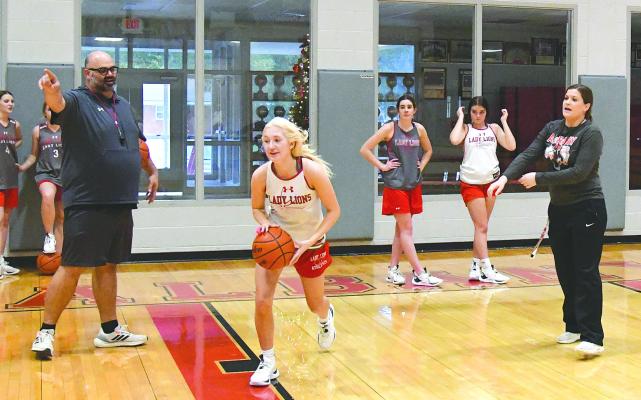 Coaches Brad Stautzenberger (l) and M.J. Reneau (r) work with Caroline Holson (c) and other members of the Lady Lions basketball team during a Monday afternoon practice. The girls hosted Gorman on Tuesday, but results weren’t available because of an early Thanksgiving week deadline. Donn ie Lucas / Albany News
