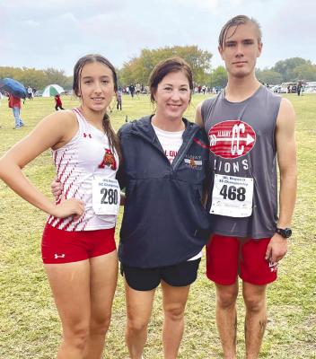 Ashlyn Miller (l) and Jonathan Coody (r) pose with cross country coach Lauren Peacock after they ran in a pouring rain at the regional meet on Tuesday. Courtesy Photo