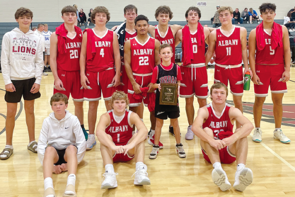 Members of the Albany Lions varsity boys basketball squad line up for a team photo (above) after winning four straight games to earn the championship at the Lingleville tournament last Thursday and Saturday, defeating Newcastle, Blu! Dale, Strawn, and Richland Springs.